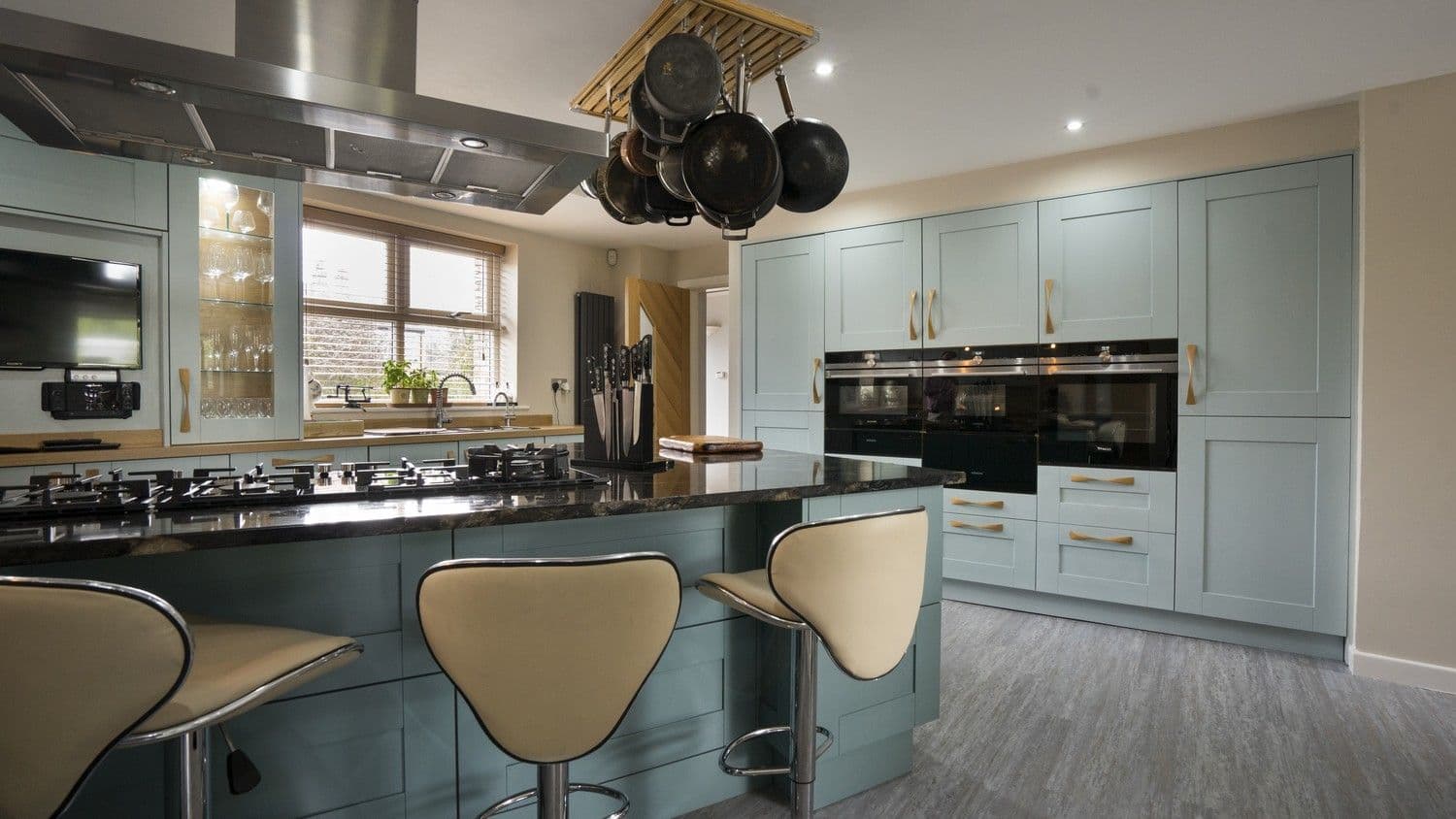 Floor to ceiling cupboards house multiple integrated cooking appliances including dual ovens, microwave and plate warmer.