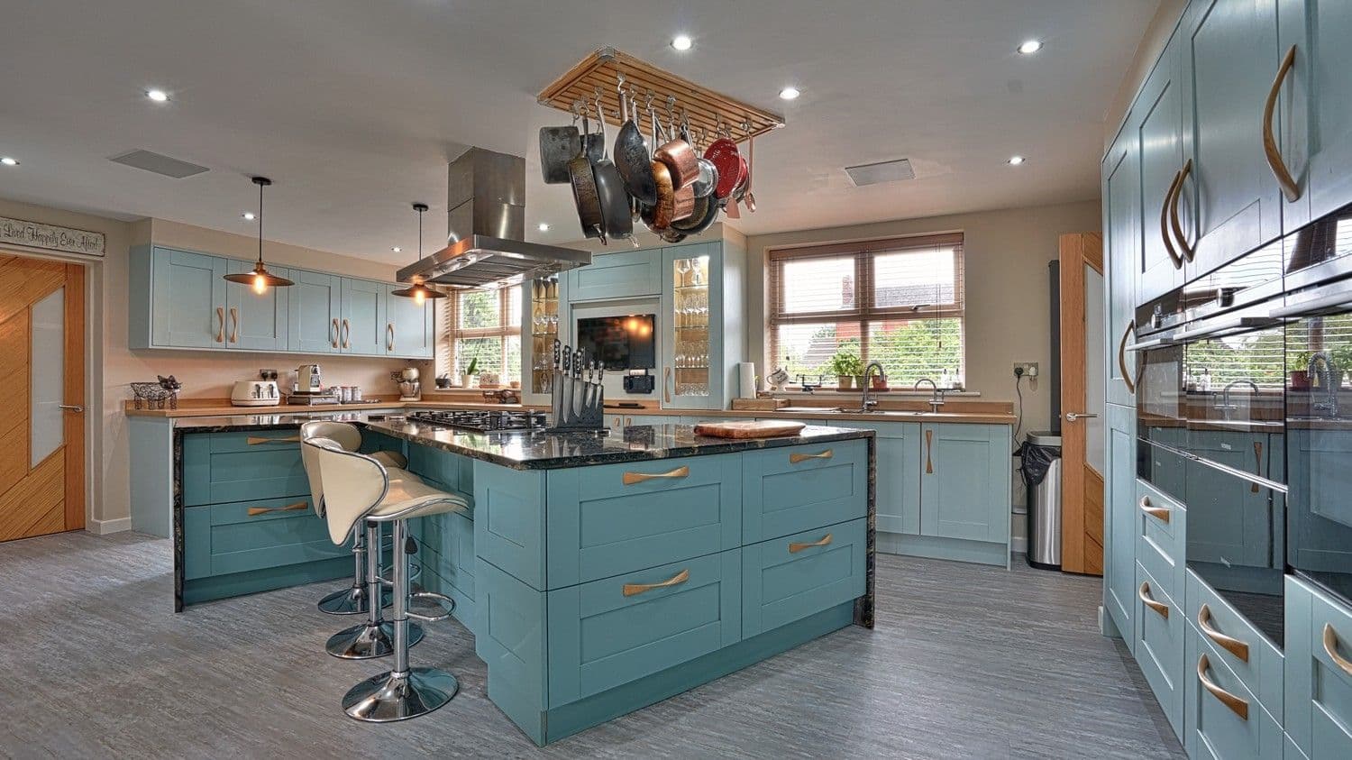 Large blue shaker kitchen with unique granite topped island with space for cooking, entertaining and dining.