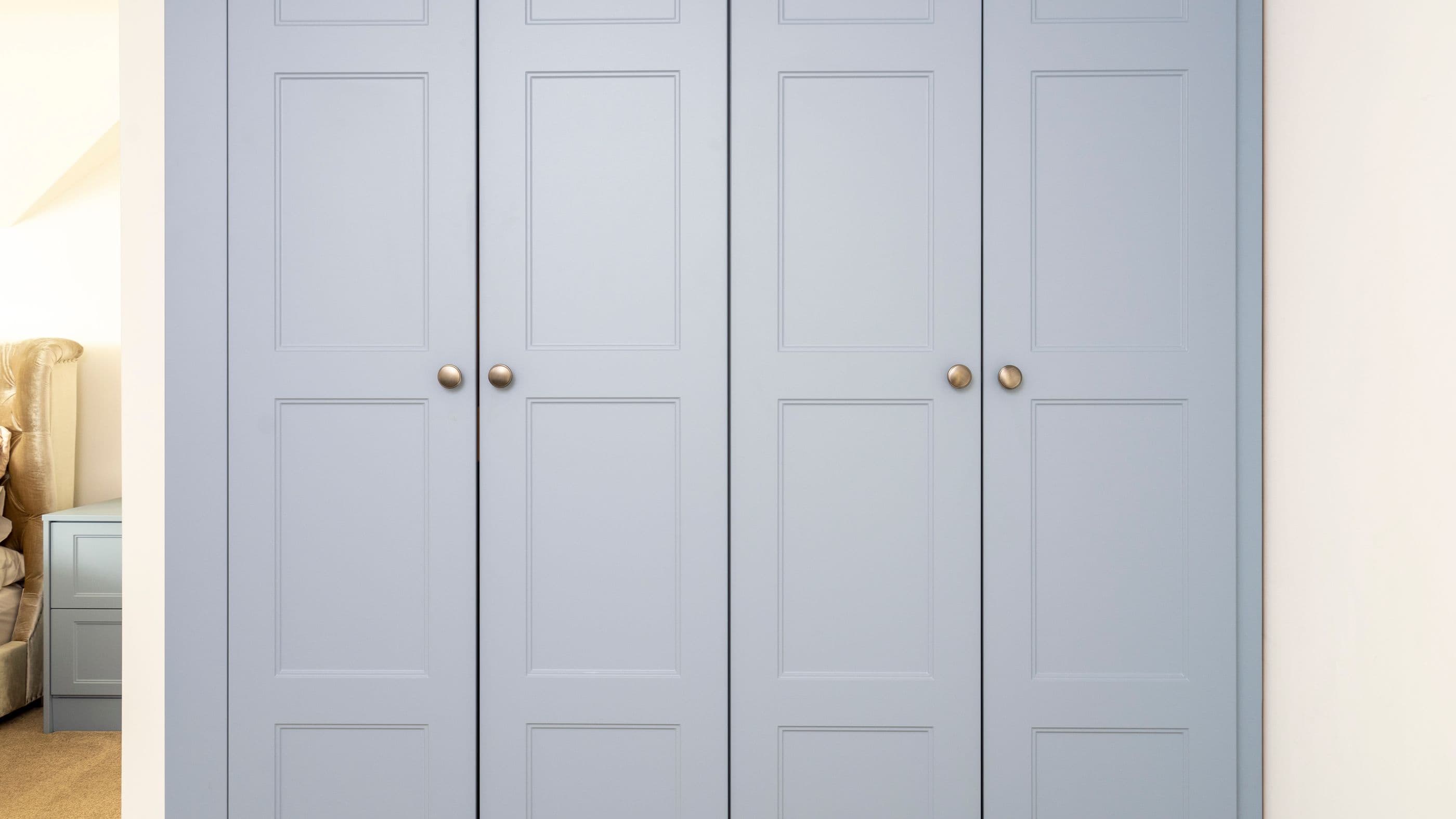 Blue shaker fitted wardrobes close up with round knob handles.