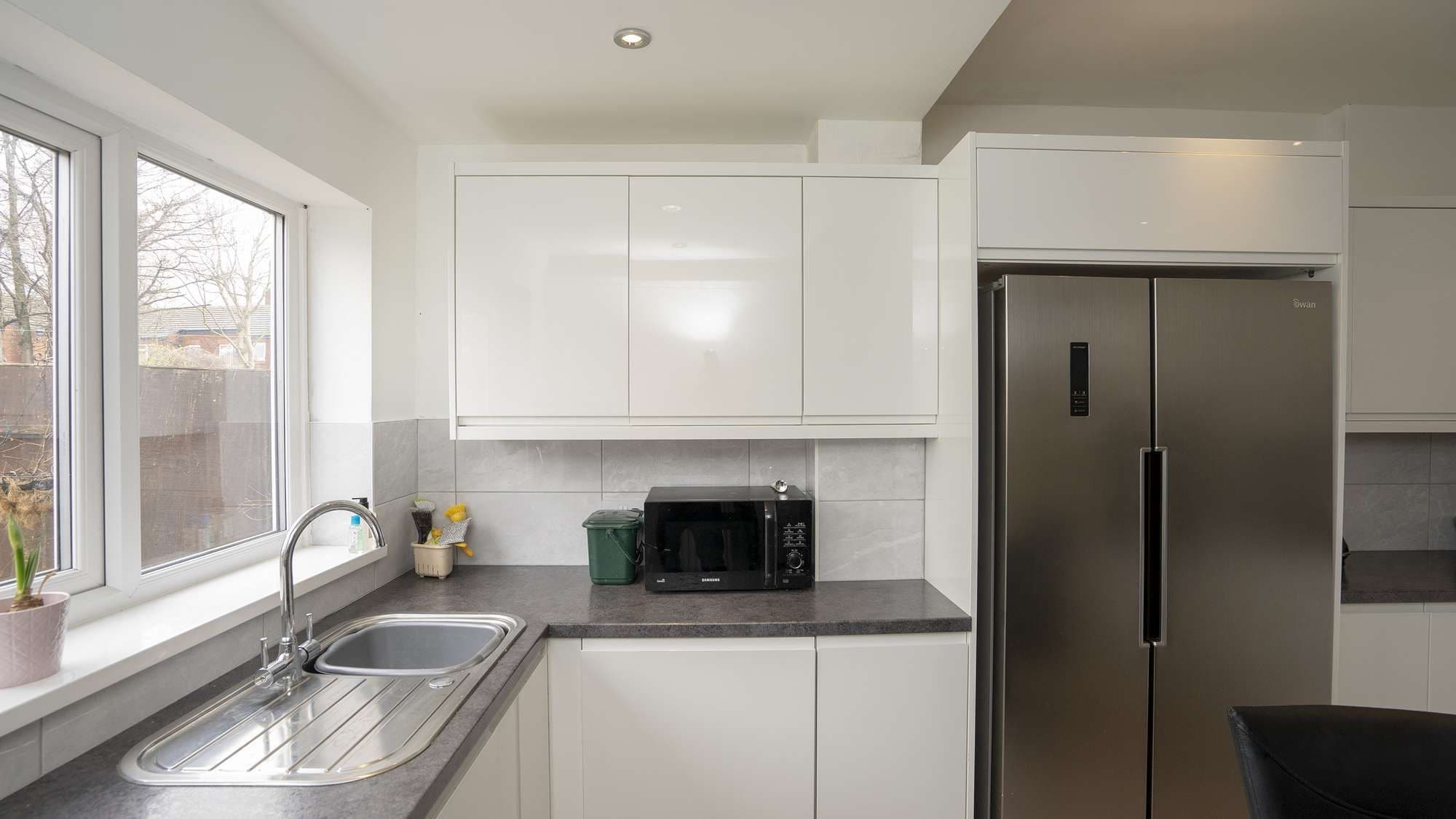 Straight on view of the sink and fridge area.