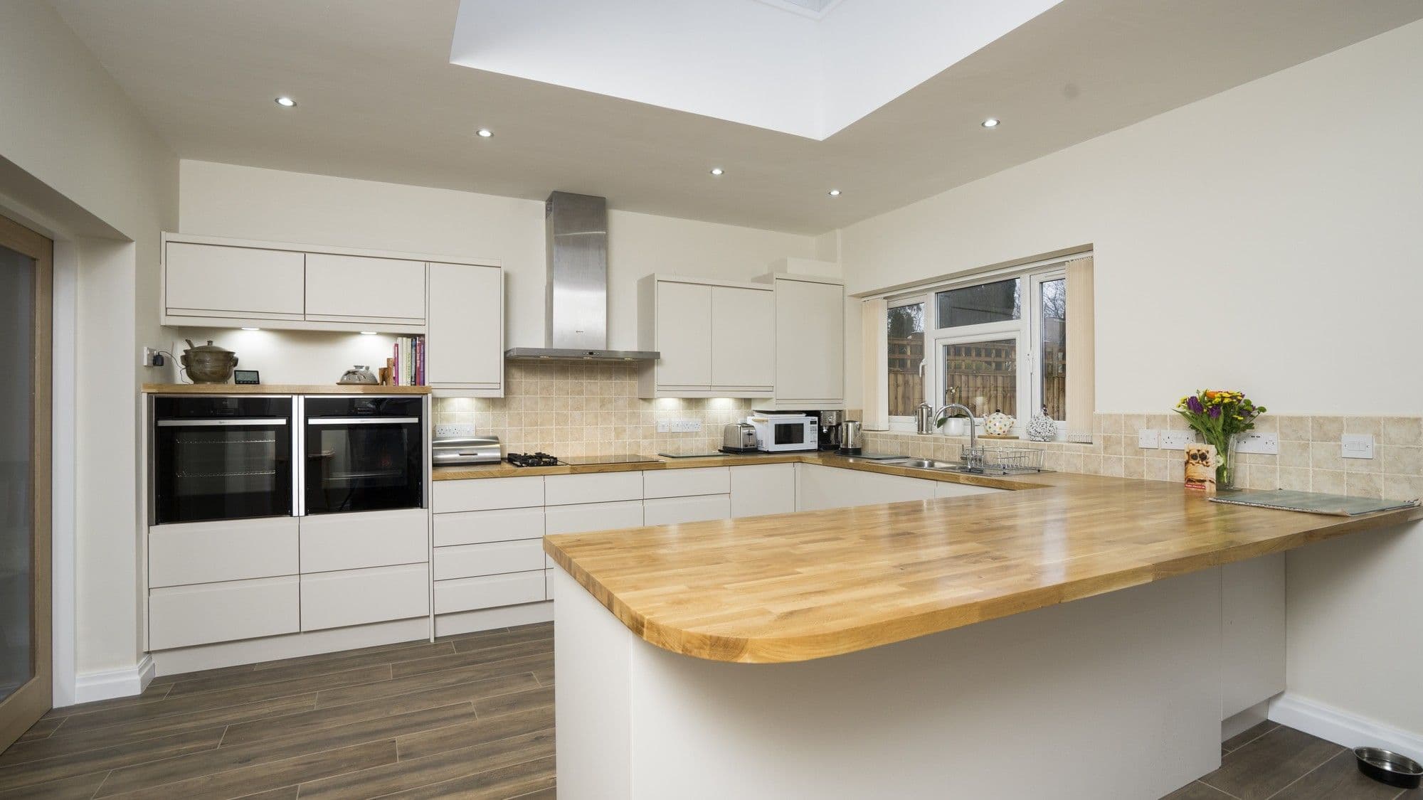 Close up of the large breakfast island with oak worktop and plenty of seating space.