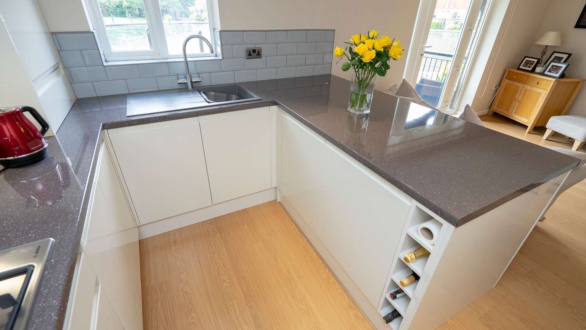 Close up of the lower cupboards with built in wine rank and large storage cupboards.
