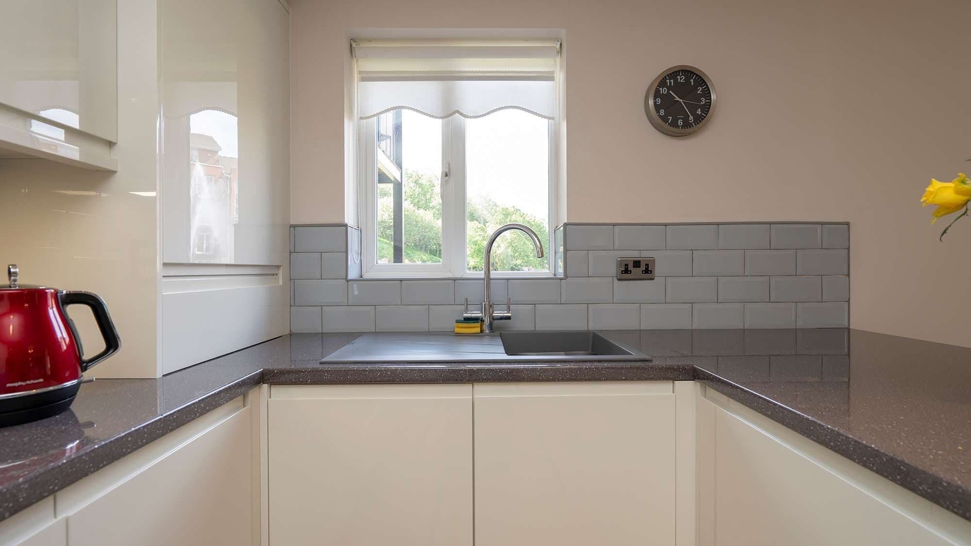 Close up of the sink area with chrome tap and grey composite sink.