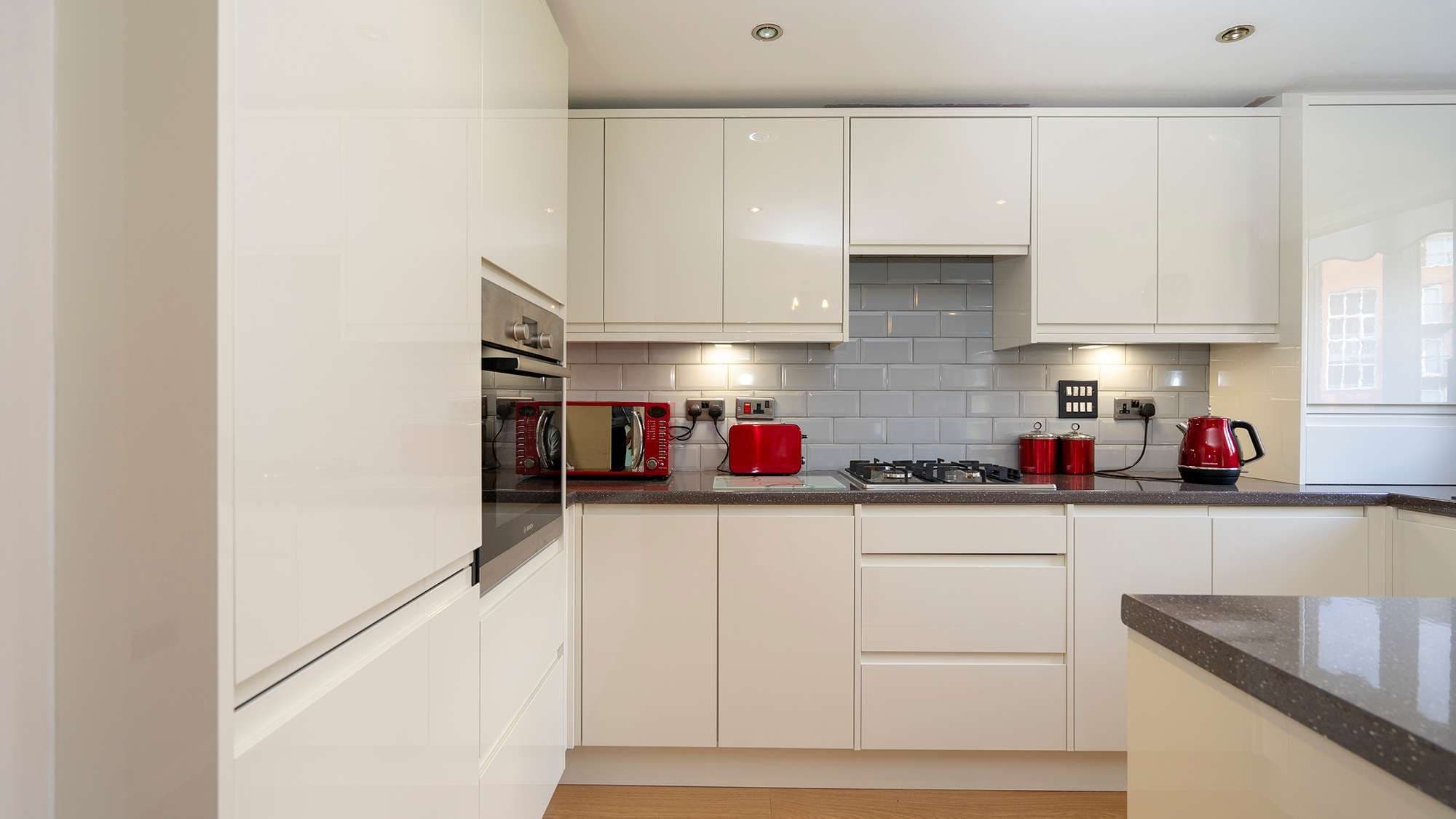 Straight on view of the kitchen installation showing the handle-less doors and concrete effect laminate worktops.