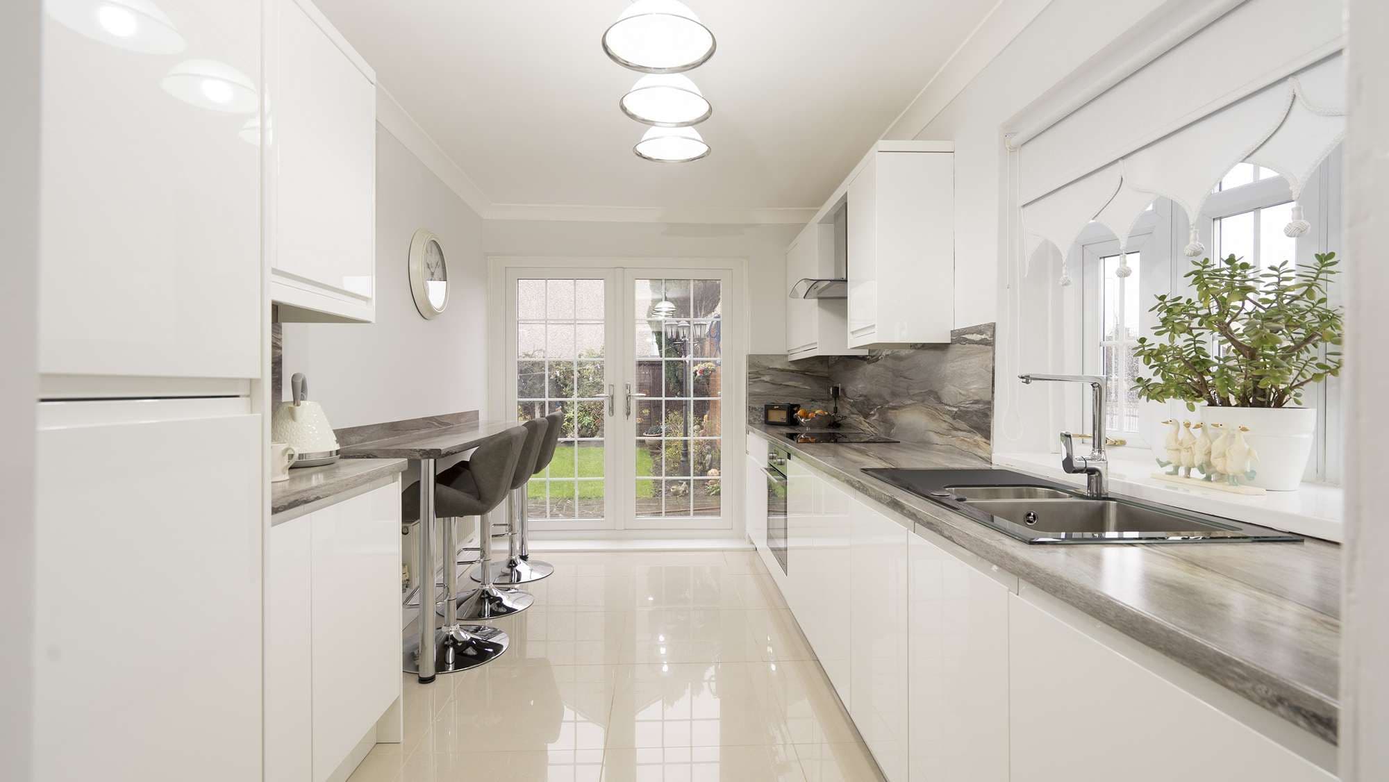 Straight on view of this kitchen door replacement in Liverpool featuring gloss white doors and brand new matching worktops and backsplash.