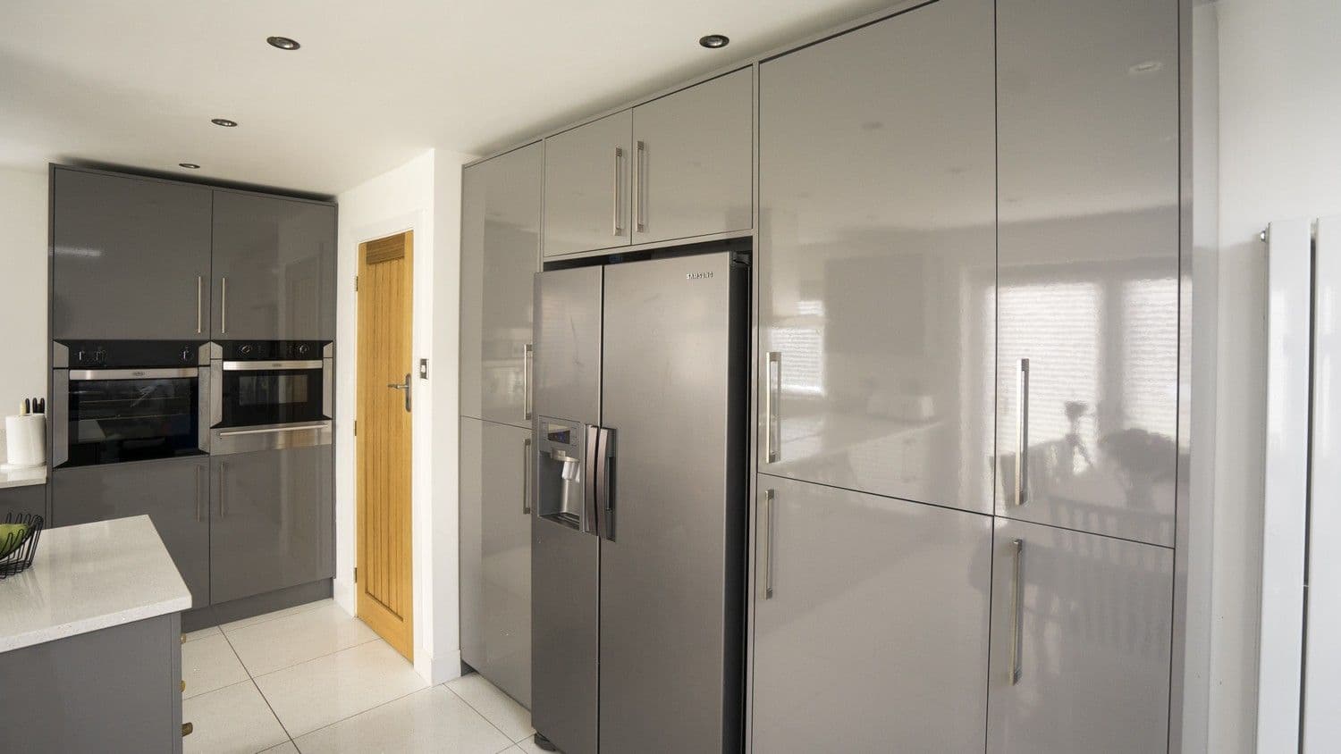 Close up of the large American fridge/freezer housed within oversized floor to ceiling larder units.