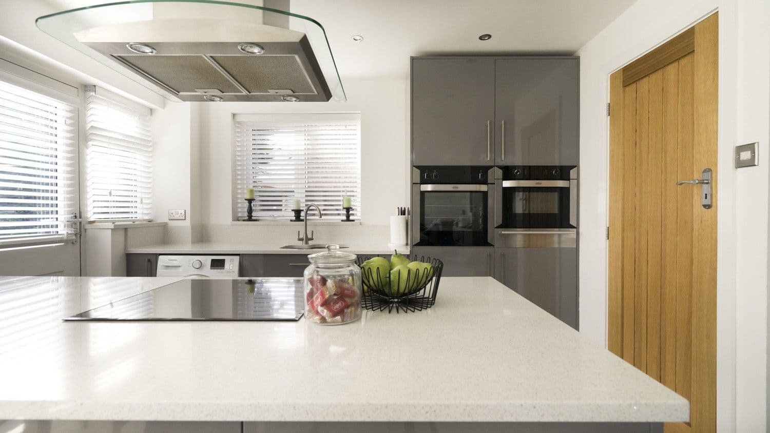 Grey gloss slab kitchen units with housing for the family washing machine.
