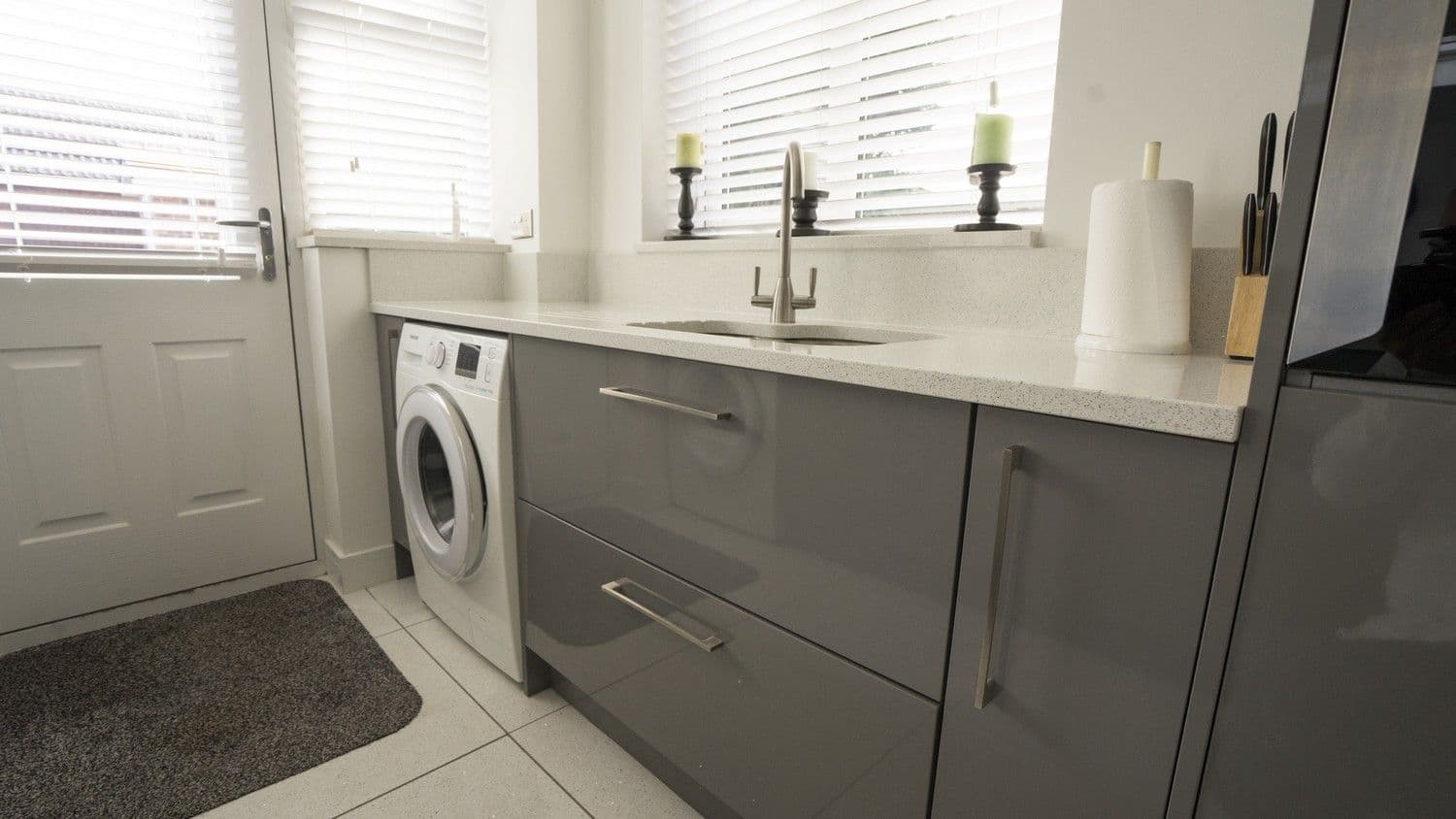 Close up of the grey gloss kitchen drawers with stainless steel handles.