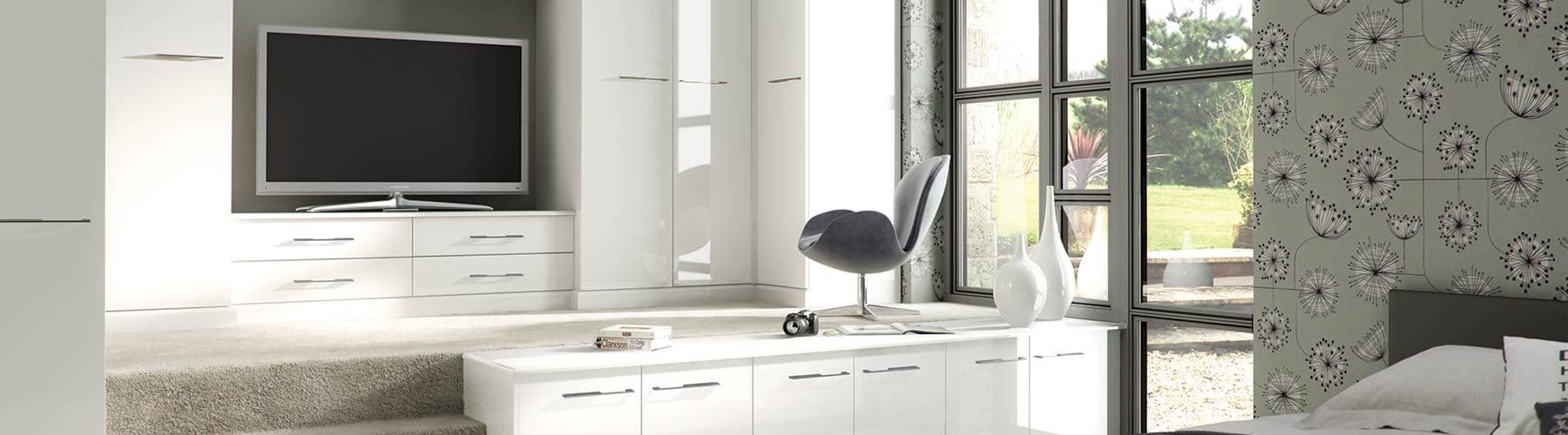 White gloss fitted bedroom furniture with built-in TV unit and drawers