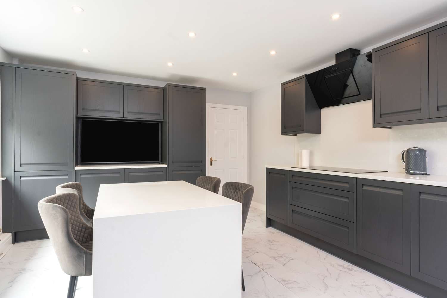 Handle-less shaker kitchen with painted ash door and quartz worktops.