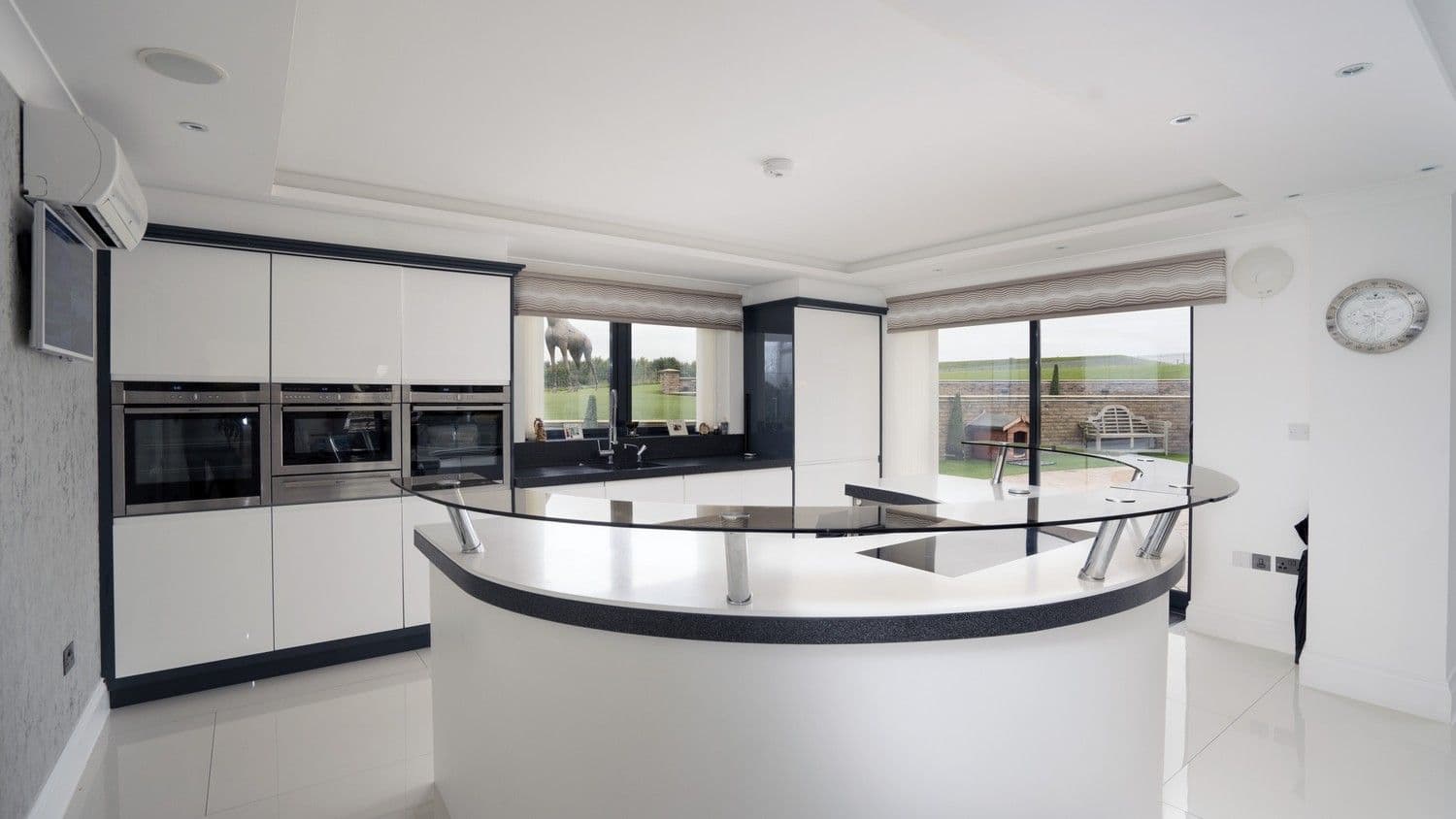 Main shot of this stunning designer kitchen in Liverpool, featuring various integrated NEFF appliances, built-in sink and flush ceramic hob.