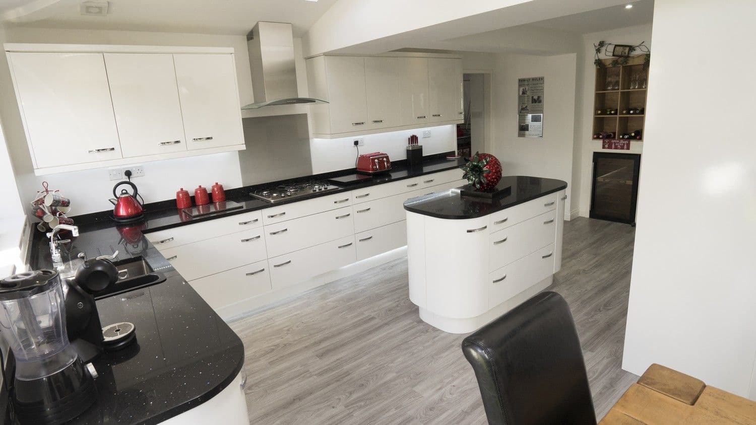 View from above of the white gloss slab kitchen with contrasting mirror black granite work surfaces.