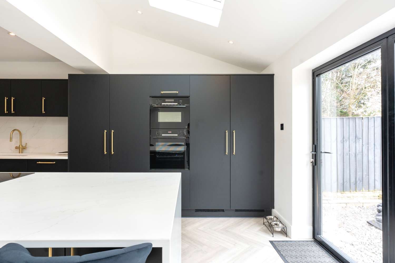 Straight on view of kitchen cupboards and bifold doors.