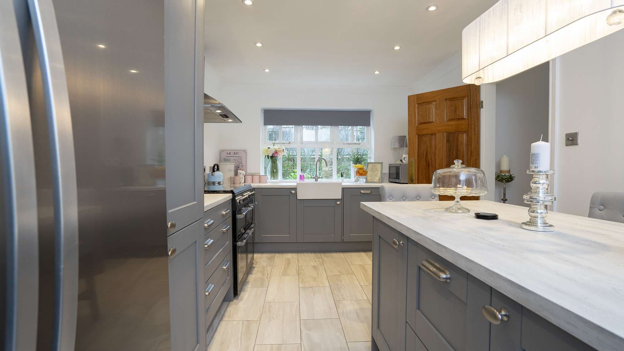 Straight on view of the grey shaker kitchen with white faux wood worktops.