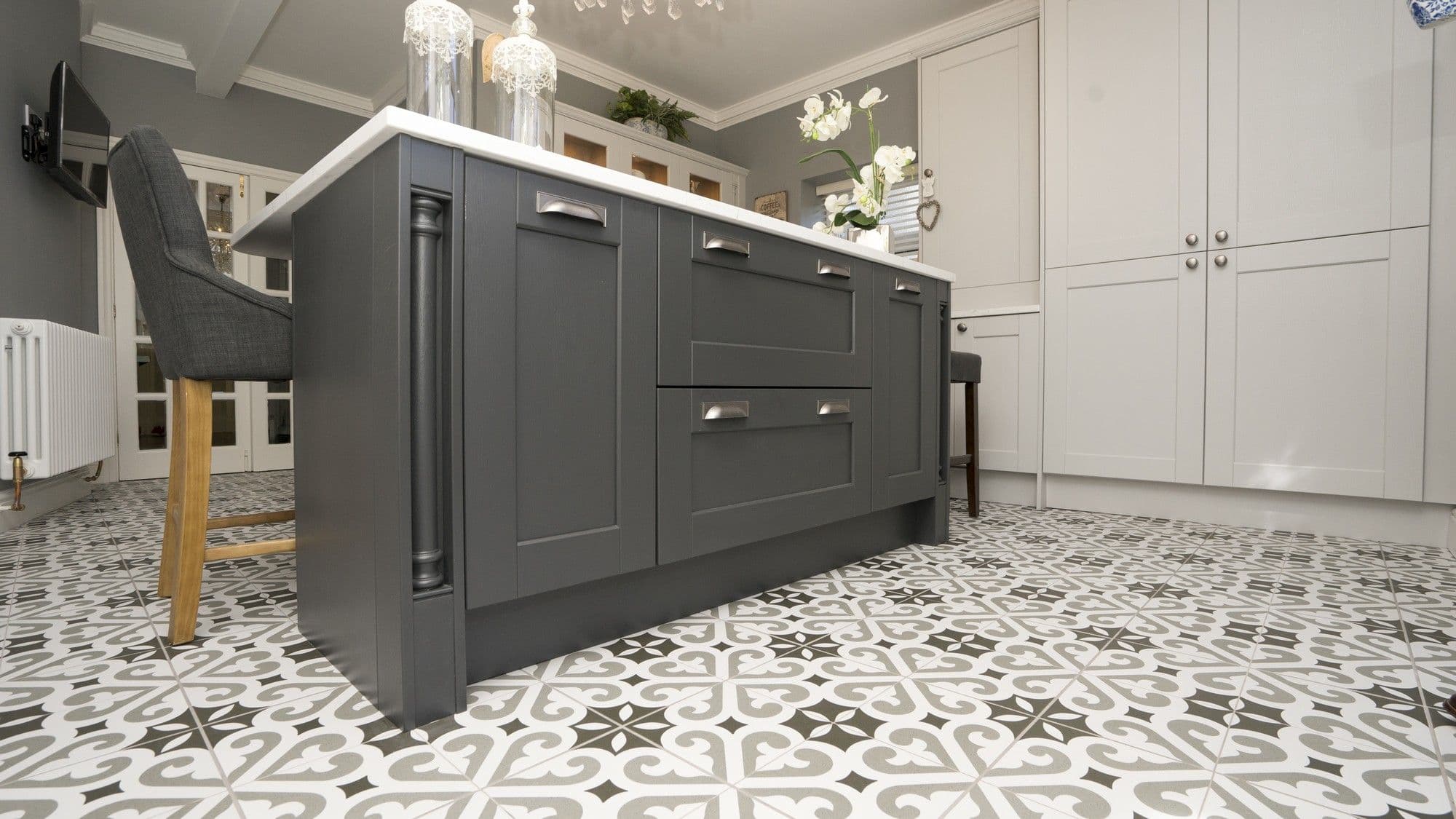 Close up of the kitchen island details including contrasting cupboard door colour, newel posts and granite worktop.