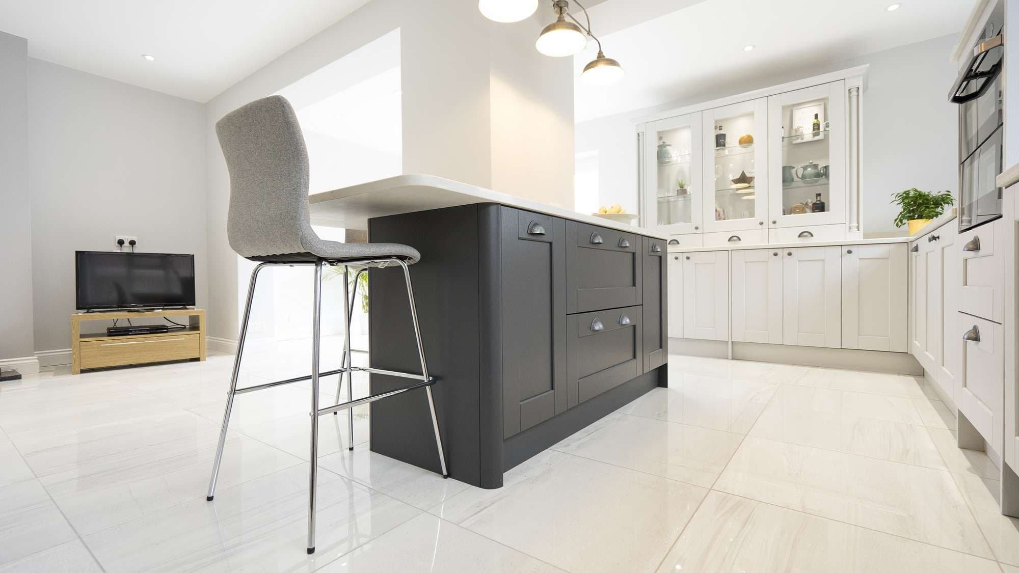 Close up of the kitchen island with shaker doors and breakfast bar seating.