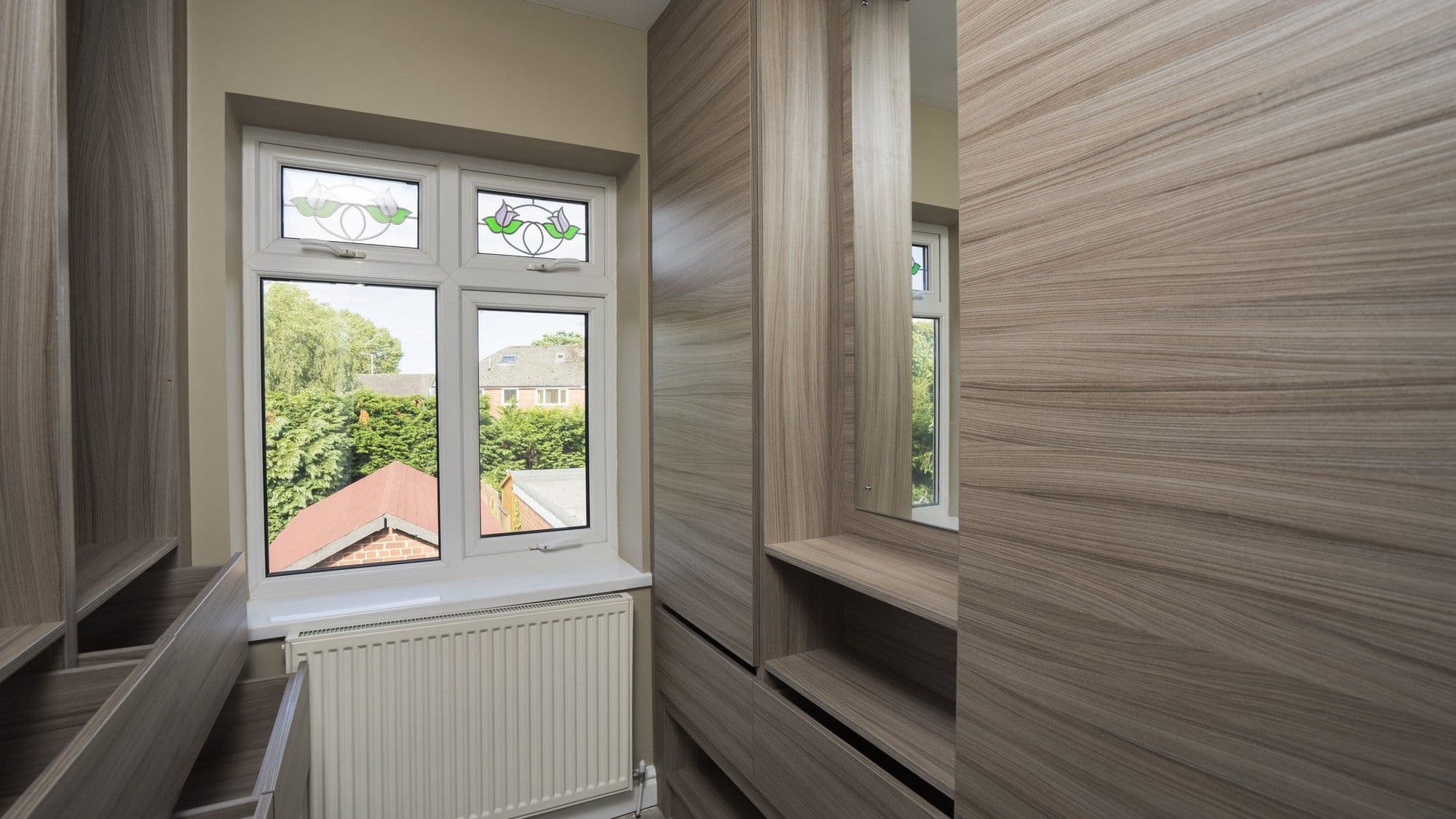 Overview of the walk in wardrobe in Wirral, showing the walnut effect doors and carcass.