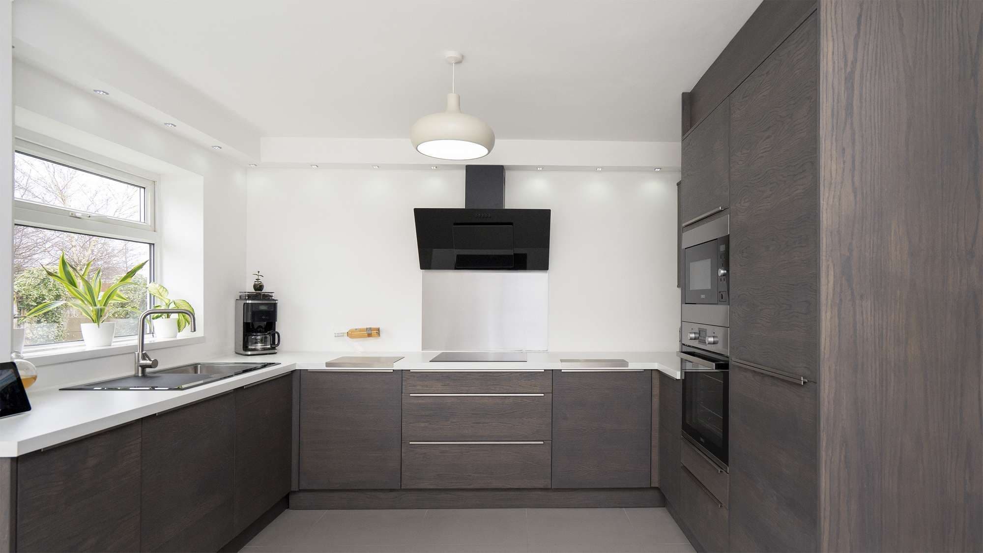 Straight on shot of the walnut slab kitchen with contrasting white worktops.