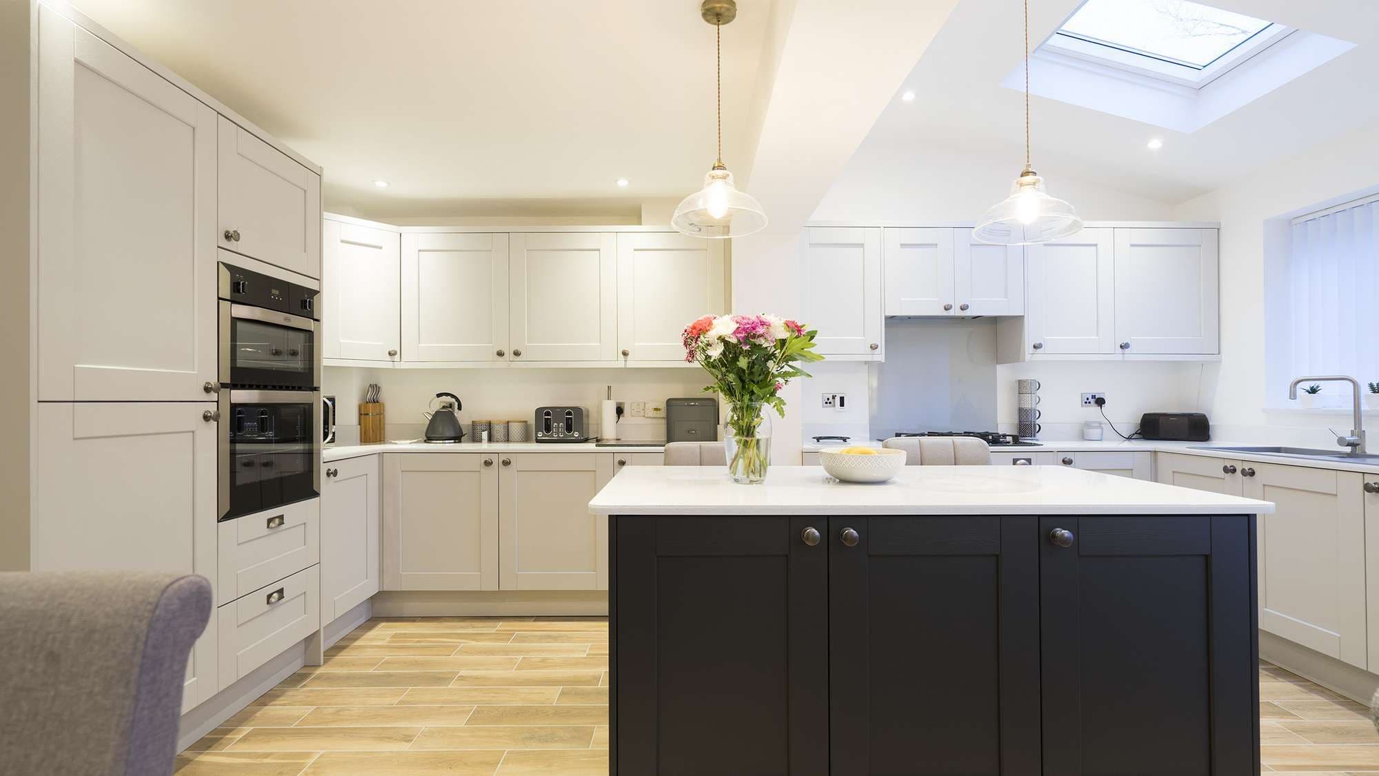 Straight on view of this two tone shaker kitchen, featuring traditional handles and drawer pulls.