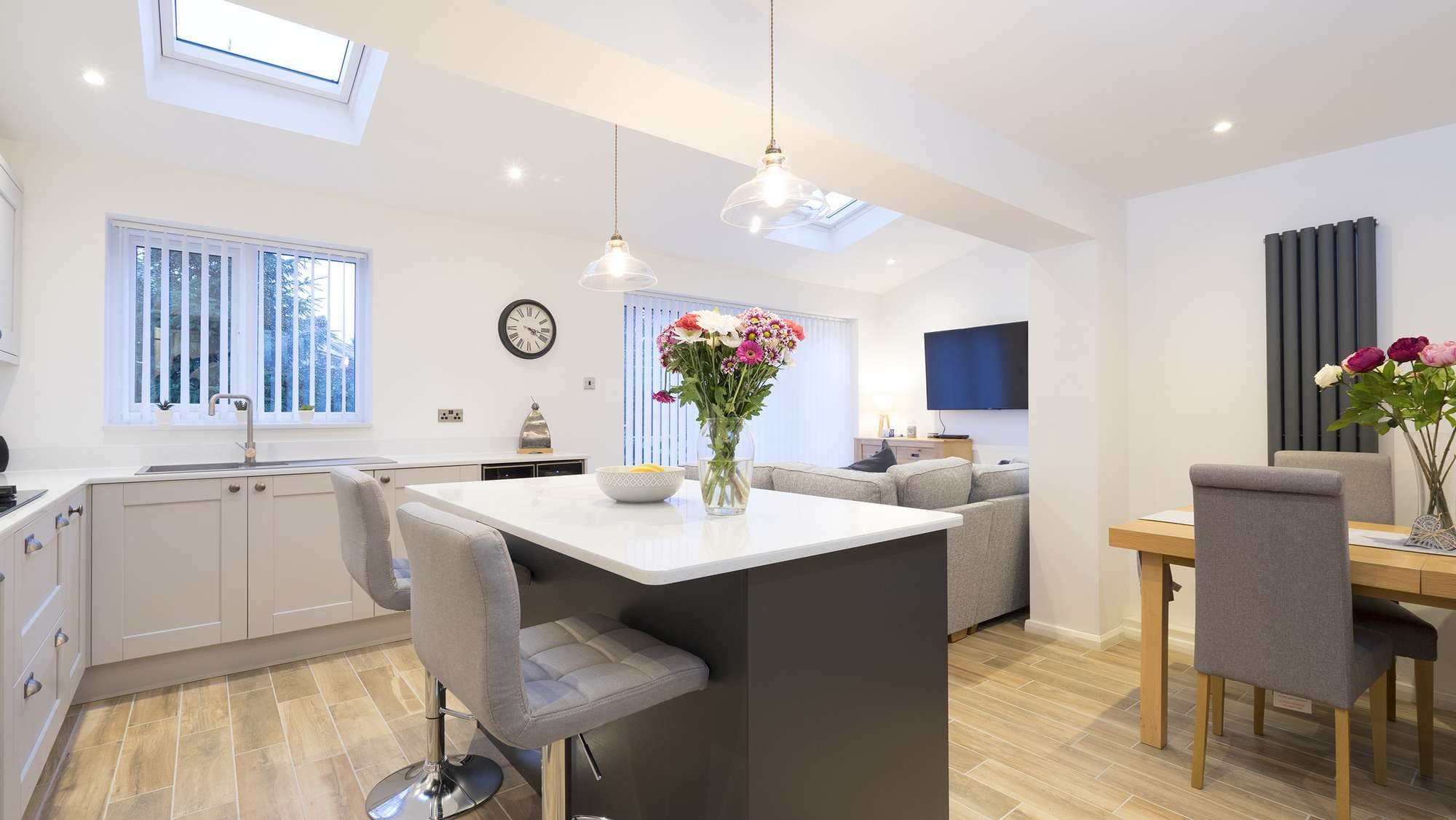 Overview of the open plan living space featuring a shaker kitchen and Corian worktops.