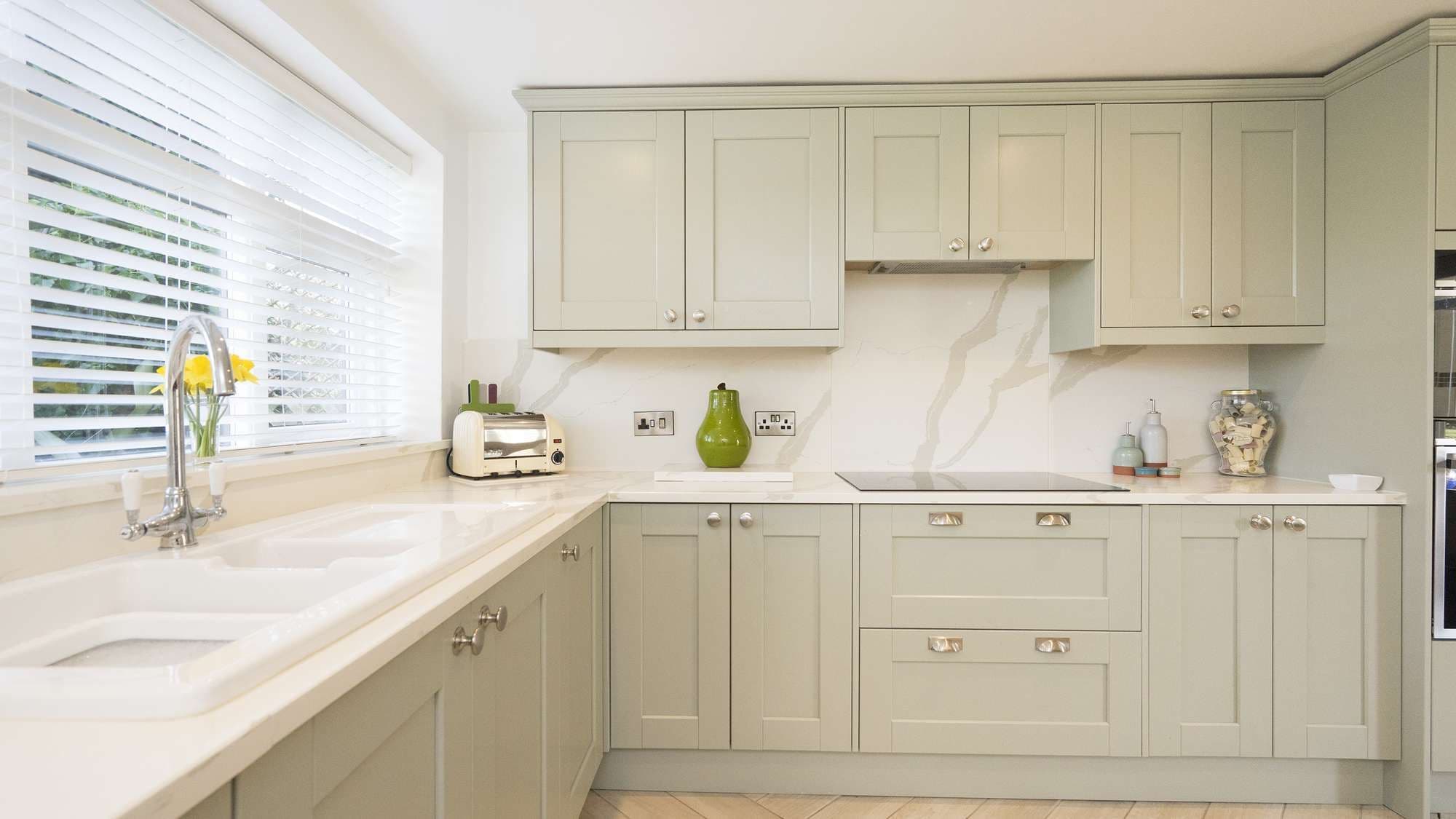 Close up of the cupboard details with traditional handles and porcelain sink on display.