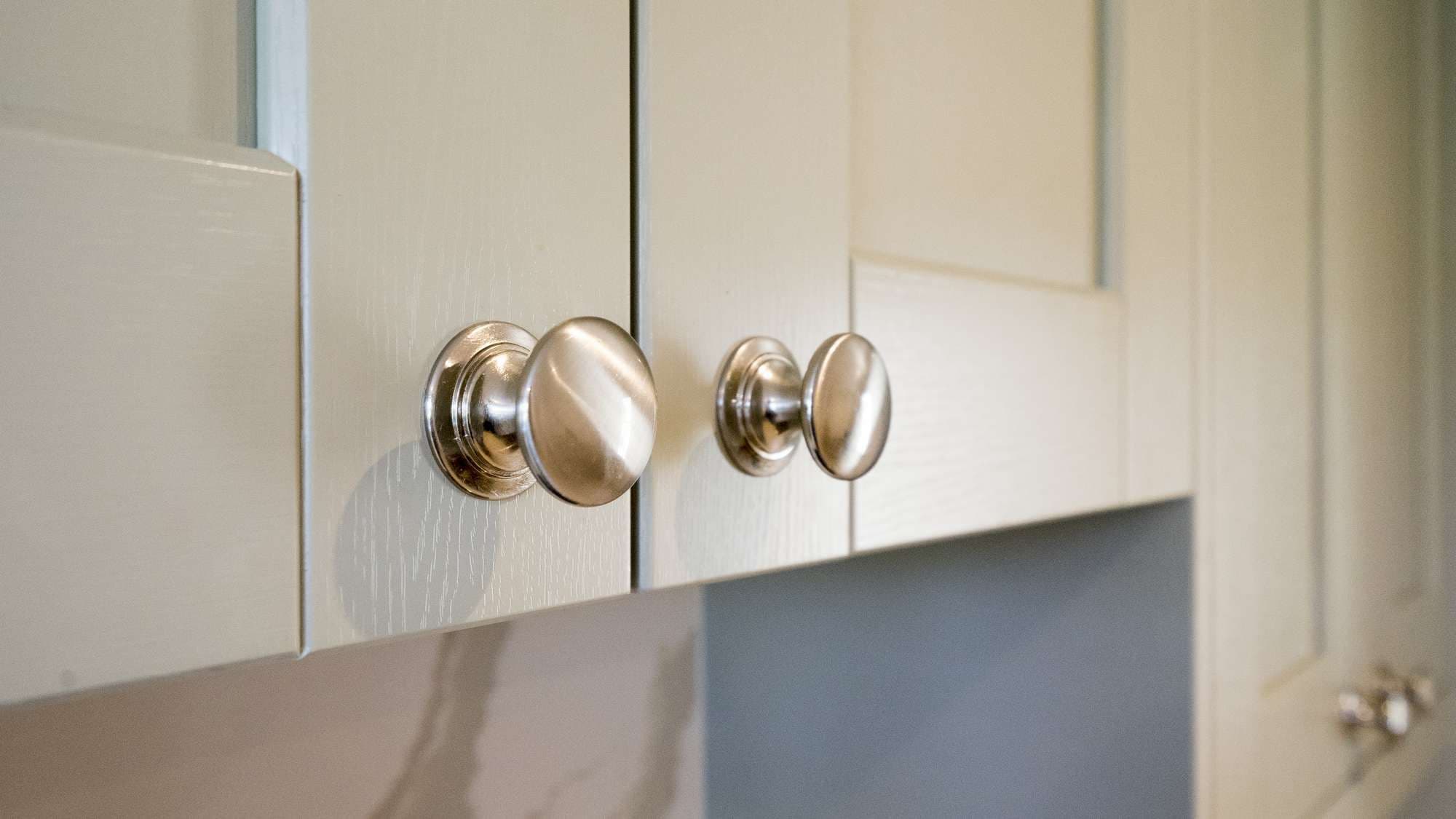 Close up of the handles and wood grain details on the cupboard doors and drawers.